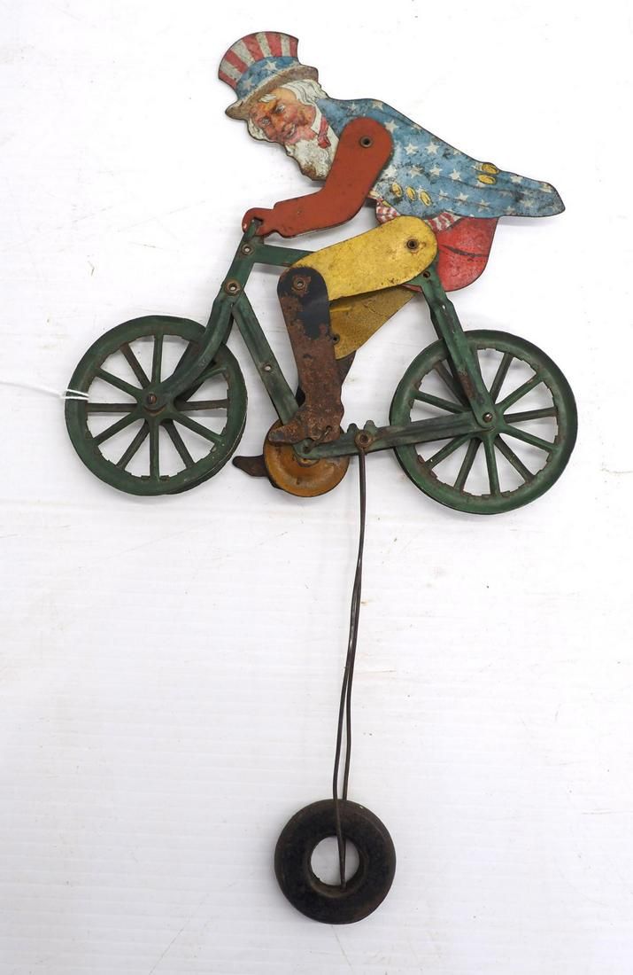 Lot 58: Uncle Sam & bike balancing tin toy