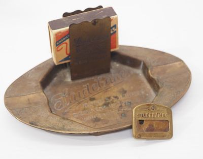 Studebaker Wagons brass ash tray with matchbox holder and Studebaker ID badge pinback