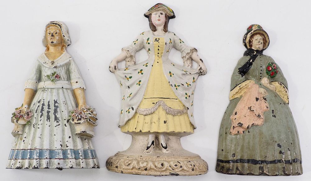 Lot 1357: (3) Lady-shaped cast iron door stops