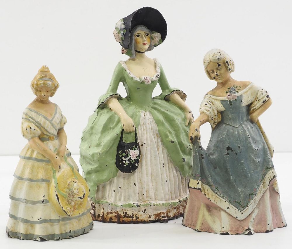 Lot 1358: (3) Lady-shaped cast iron door stops