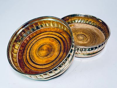 זוג תחתיות לבקבוקים כסף ועץ חתום אנגלי לונדון מתוארך 1963. קוטר 13 ס"מ, משקל ברוטו 318 גרם.