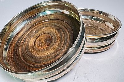 זוג תחתיות לבקבוקים כסף ועץ חתום אנגלי לונדון מתוארך 1963. קוטר 13 ס"מ, משקל ברוטו 326 גרם.