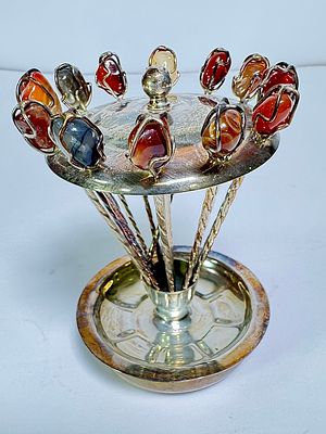 כלי עם קיסמים לנעיצה מעוטר אבני חן בחלק העליון עם צלוחית כסף בחלק התחתון חתומה אנגלי מלונדון. 