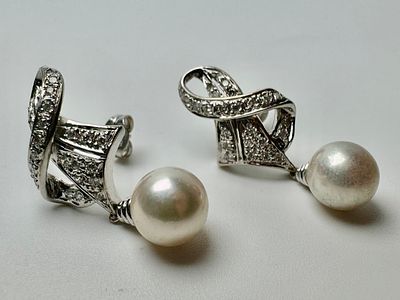 זוג עגילי זהב 18k חתום עם פנינה בקוטר 8 מ׳׳מ כל אחד ומשובץ 50 יהלומים בשני העגילים יחד בגודל 