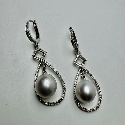 זוג עגילי זהב 14k חתום עם פנינה בקוטר כ-10 מ׳׳מ כל אחד ומשובץ 124 יהלומים בשני העגילים יחד 