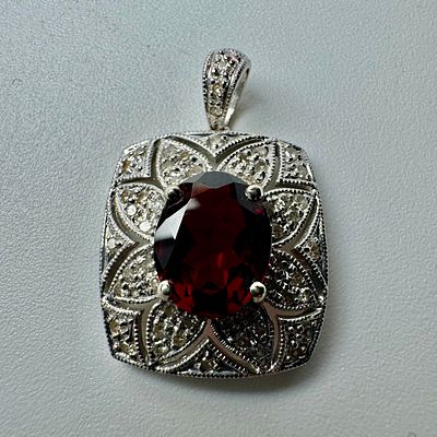 תליון זהב לבן 14k חתום משובץ 54 יהלומים בגודל 0.01ct סה׳׳כ 0.54ct וגרנט גדול במרכזבמרכז משקל 