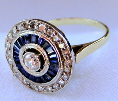 טבעת זהב לבן וצהוב 18K ארט דקו משקל 6.1 גרם משובץ יהלום מרכזי כ-0.25CT שורה של ספירים כחולים 