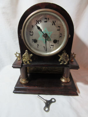 שעון שולחני יודאיקה מעוטר סיפור המרגלים בלוחית תבליט נחושת בנוי מעץ ונחושת גובה 29 ס׳׳מ גודל 