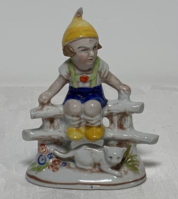 פסל פורצלן מוטבע המילה גרמניה דמות נער וחתול על הגדר גובה: 10.5 ס''מ