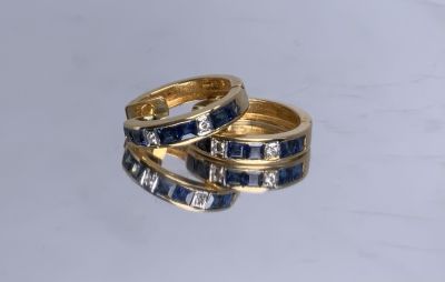 זוג עגילי זהב 18K משובץ 12 ספירים כחולים בשיבוץ בלתי ניראה ועוד 4 יהלומים (אחד מהם צריך לשבץ 