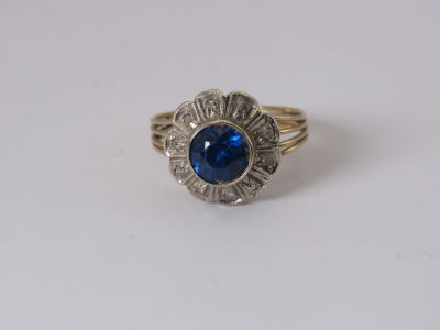 טבעת זהב לבן וצהוב 14K משובץ אבן חן כחולה במרכז עם 10 דיאמנטים טבעת בדוגמת פרח משקל 4.6 גרם 