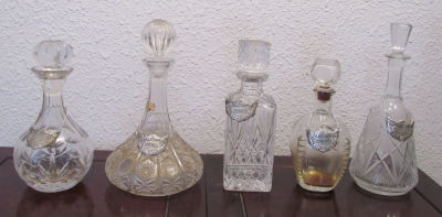 לוט בקבוקי משקאות זכוכית וקריסטל עם התוויות של המשקאות:וודקה, ברנדי, ג'ין, ברבן ווויסקי עם 