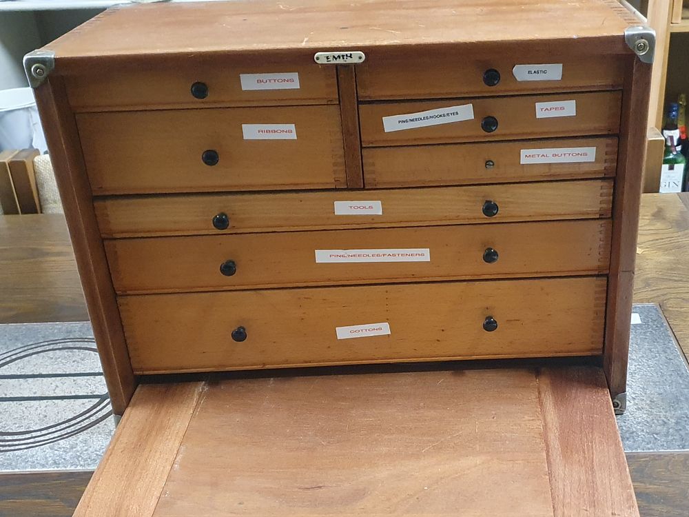 Lot 259: An 8 drawer wooden cabinet currently filled with sewing materials
