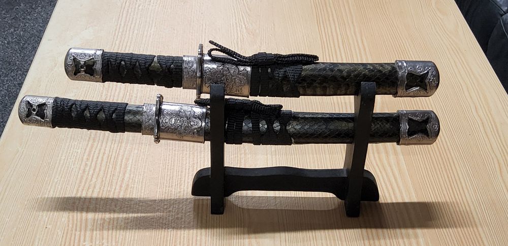 Lot 211: Pair of small Samurai sword letter openers on stand.