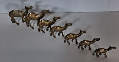 Herd of 7 brass camel figurines . As pictured