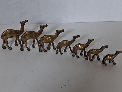 Herd of 7 small brass camels. As pictured