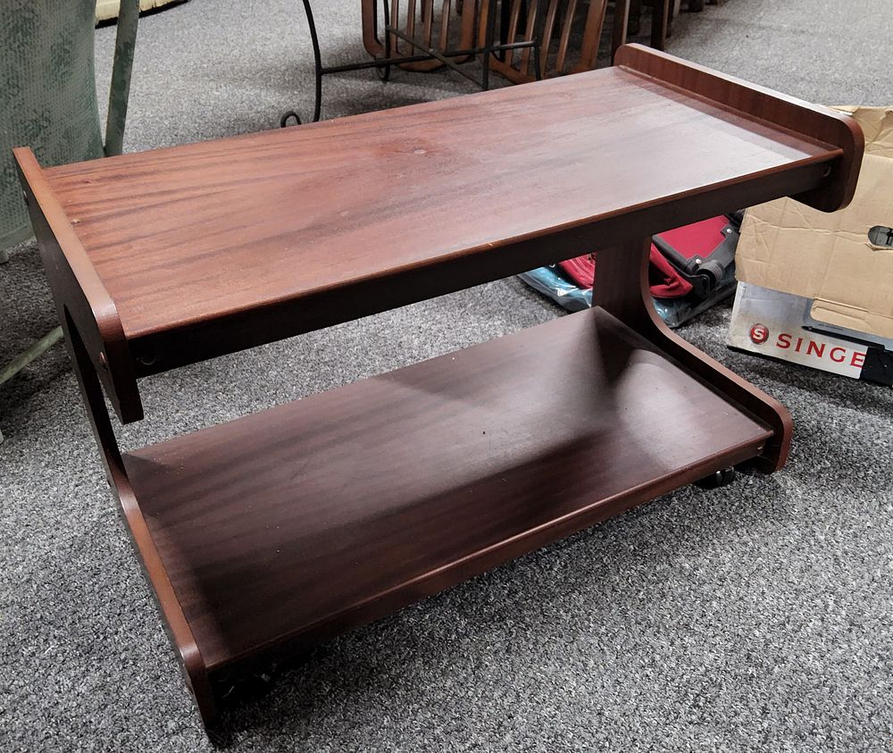 Lot 270: two-tier wooden end table/ coffee table with a dark finish and rounded edges. On castors.
L 31"
W 15"
H 18".