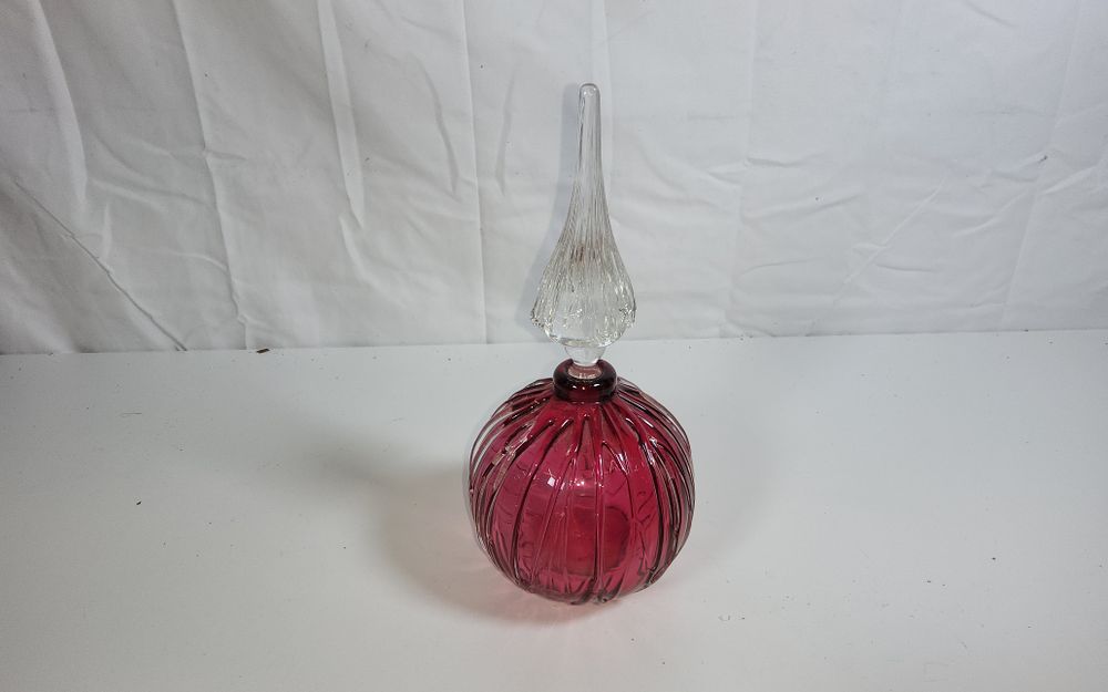 Lot 172: Vintage ribbed Cranberry glass perfume bottle with a clear, spire-shaped stopper, similar in style to those produced in the late 19th or 20th century height 8.5"