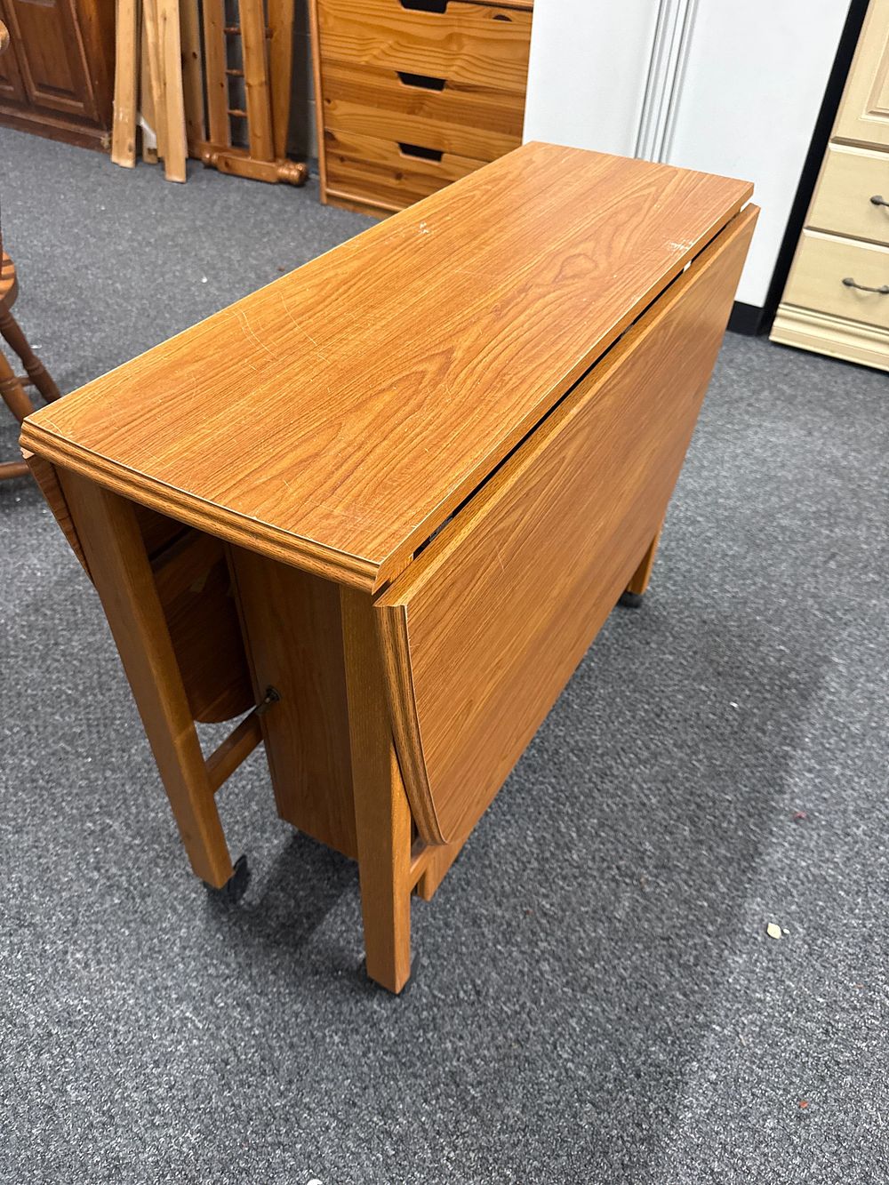 Lot 163: A late 20th-century wood-effect laminate drop-leaf gate-leg dining table