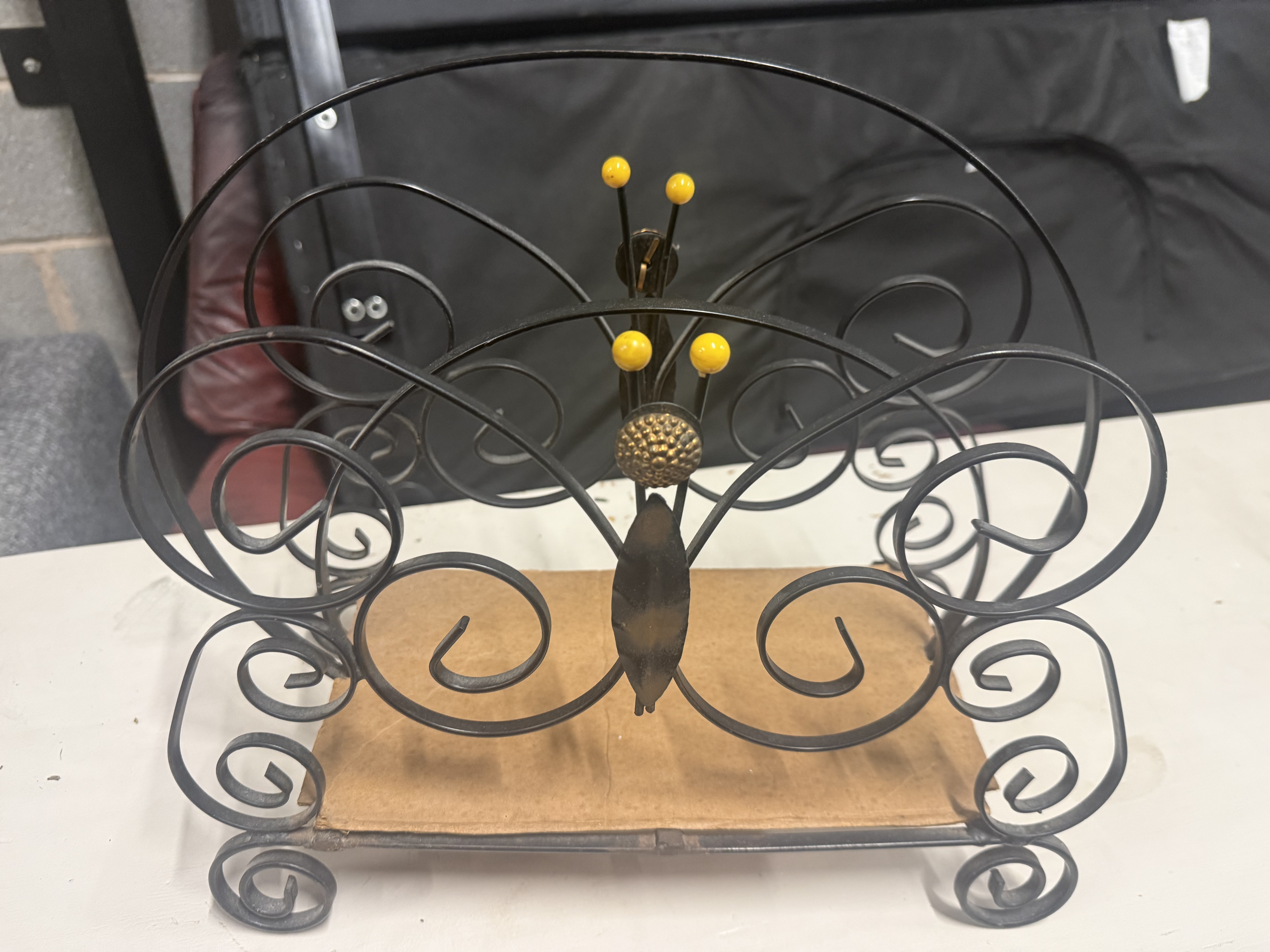 A mid-century black wrought metal butterfly Magazine Rack