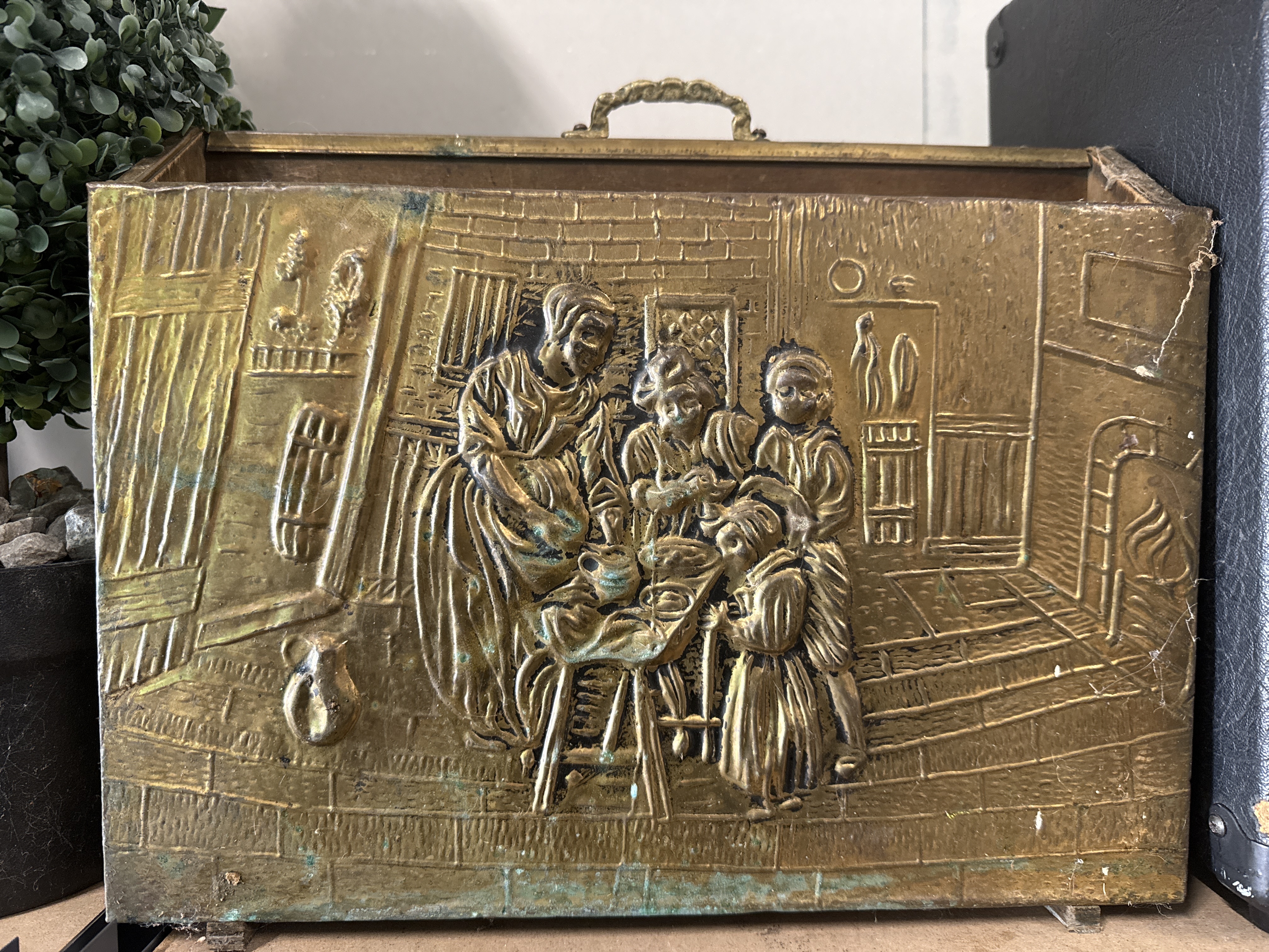 Embossed brass fireside log box with domestic interior scene