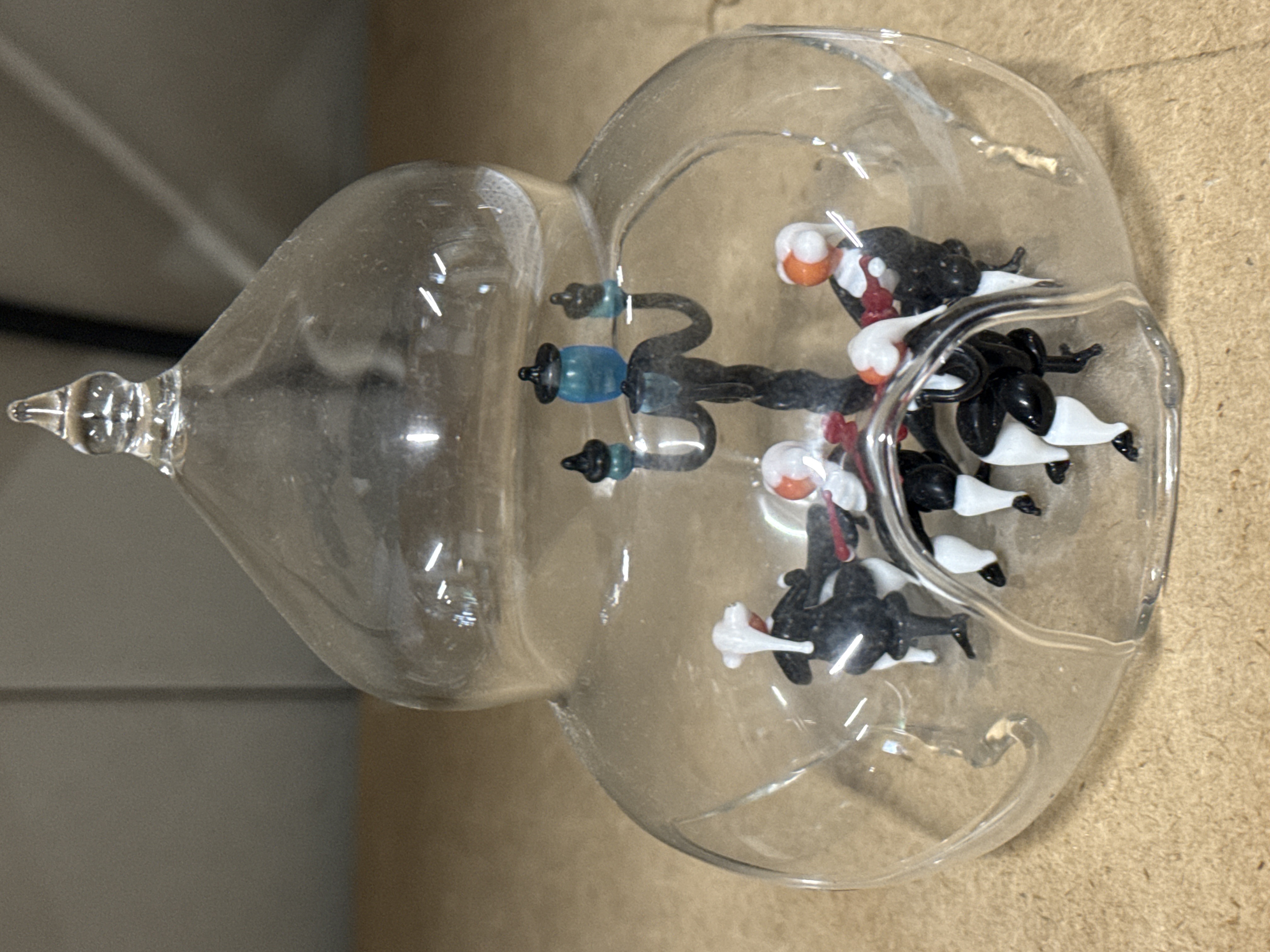 Miniature lampworked glass musical quartet under a glass dome
