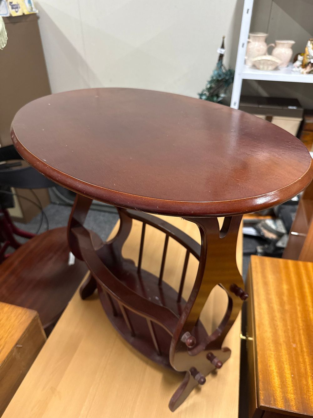 Lot 204: Mid-20th-century oval mahogany stained side table with magazine rack