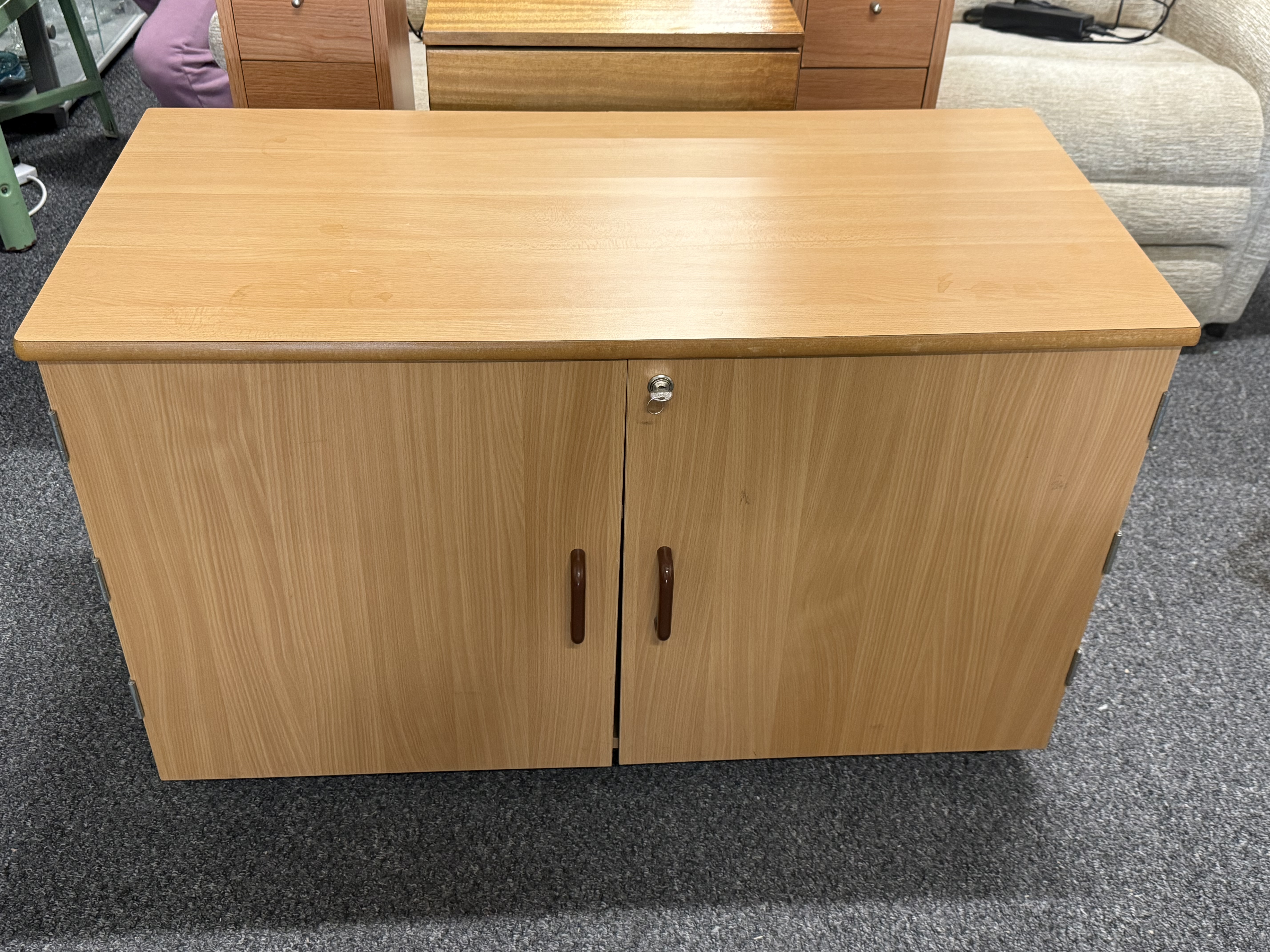 A contemporary beech-effect two door lockable storage cabinet