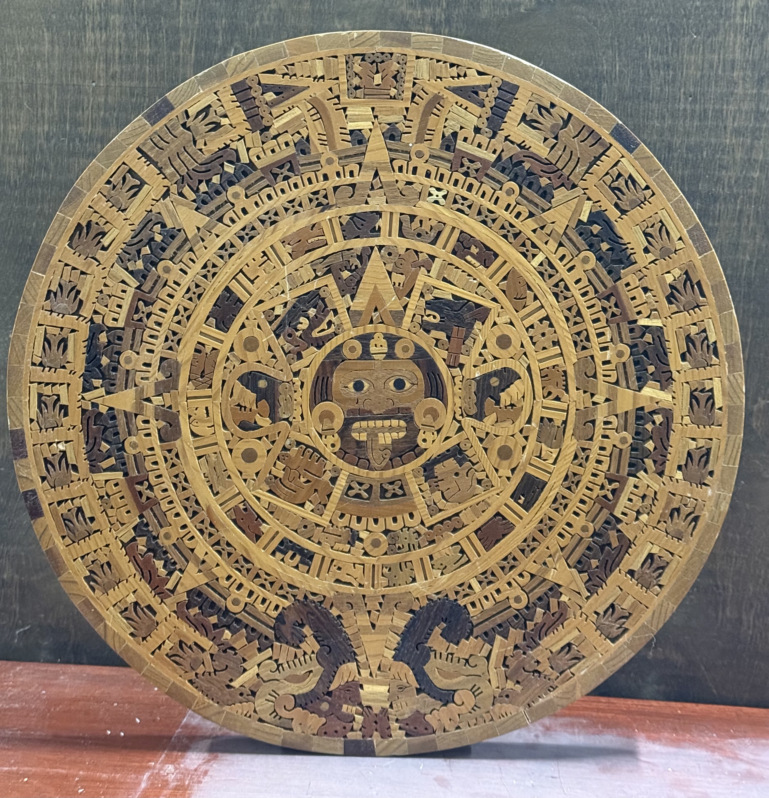 Large circular Mexican marquetry plaque depicting the Aztec Sun Stone
