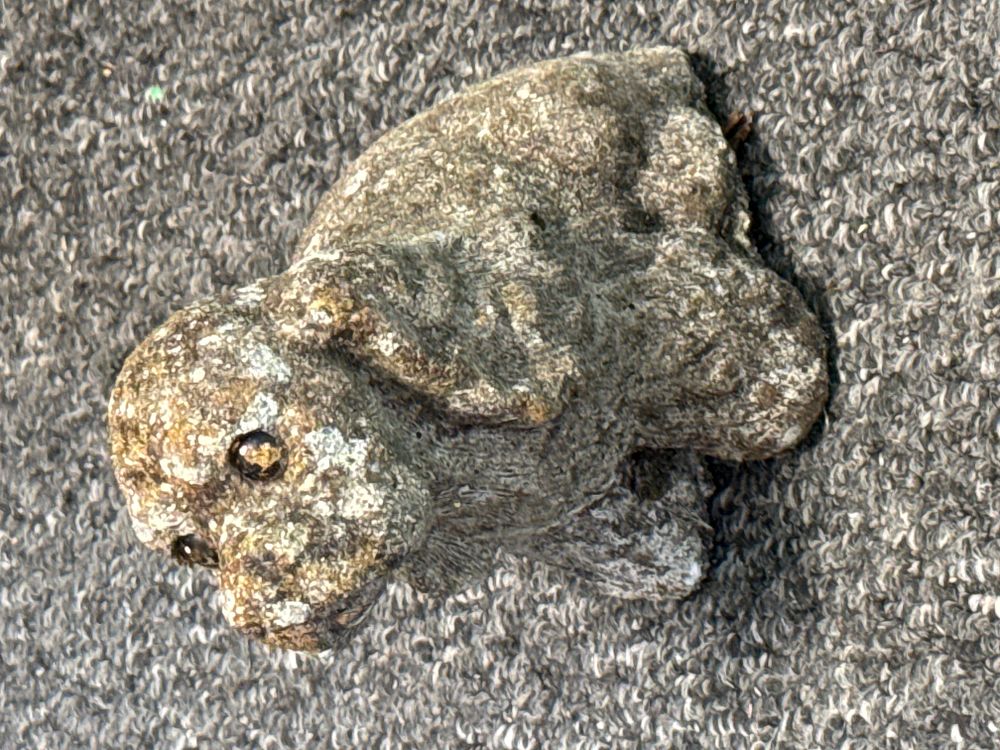 Lot 261: A weathered reconstituted stone garden ornament of a seated puppy
