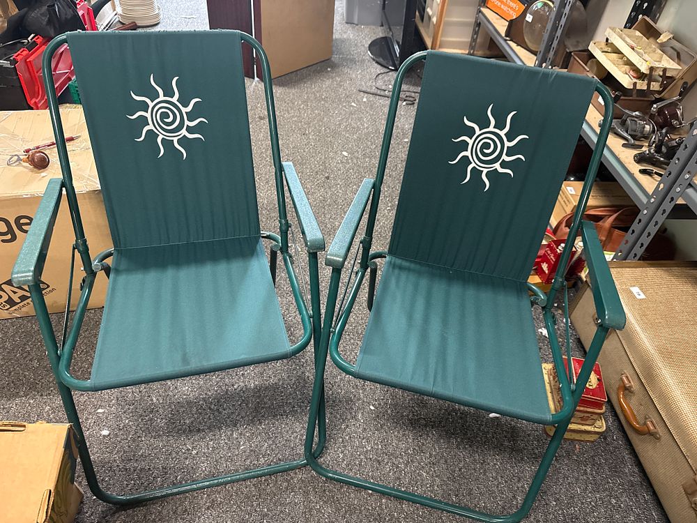 Lot 218: A pair of green folding metal outdoor chairs with sun motif