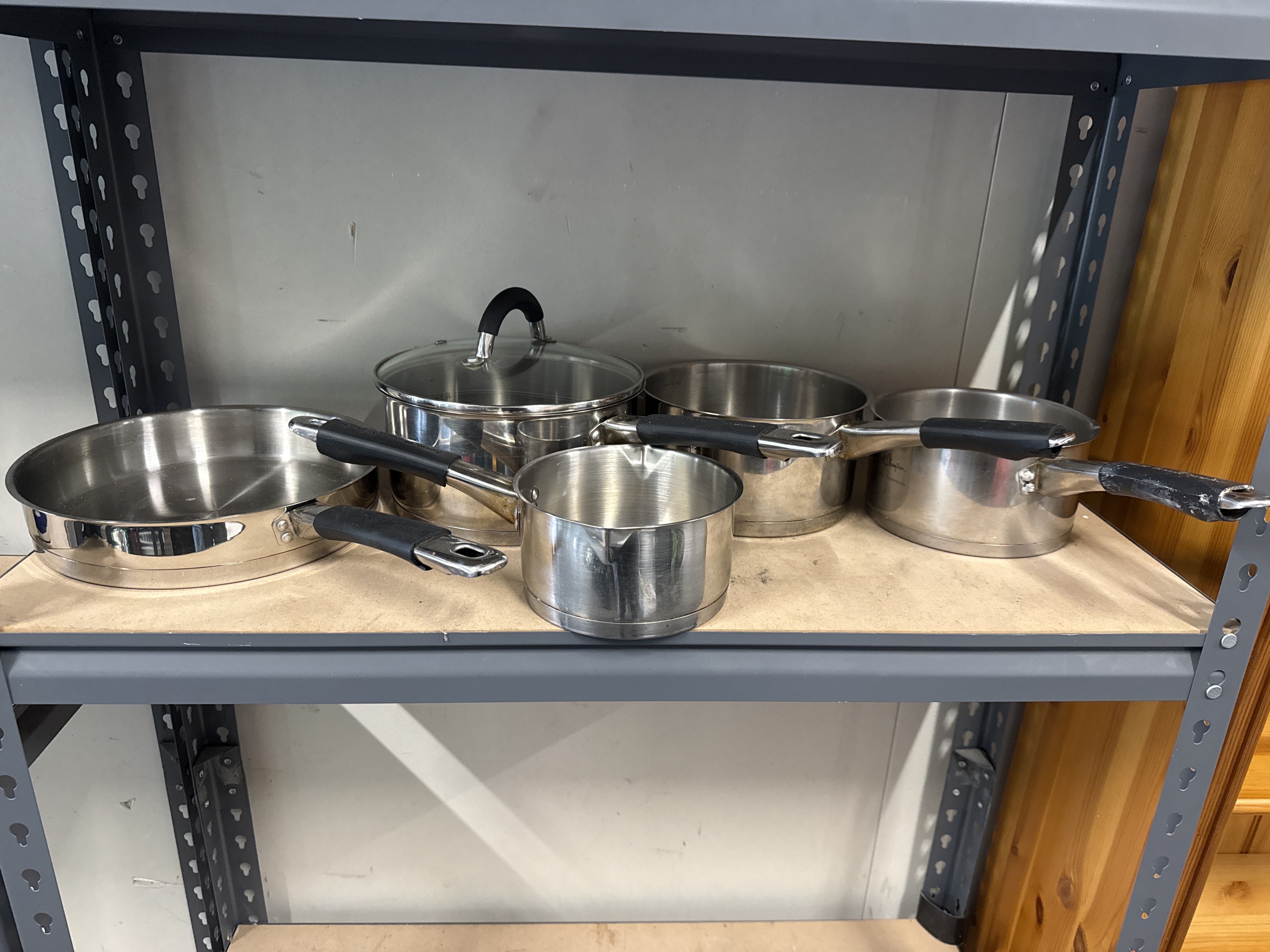 An assortment of stainless steel saucepans and a frying pan