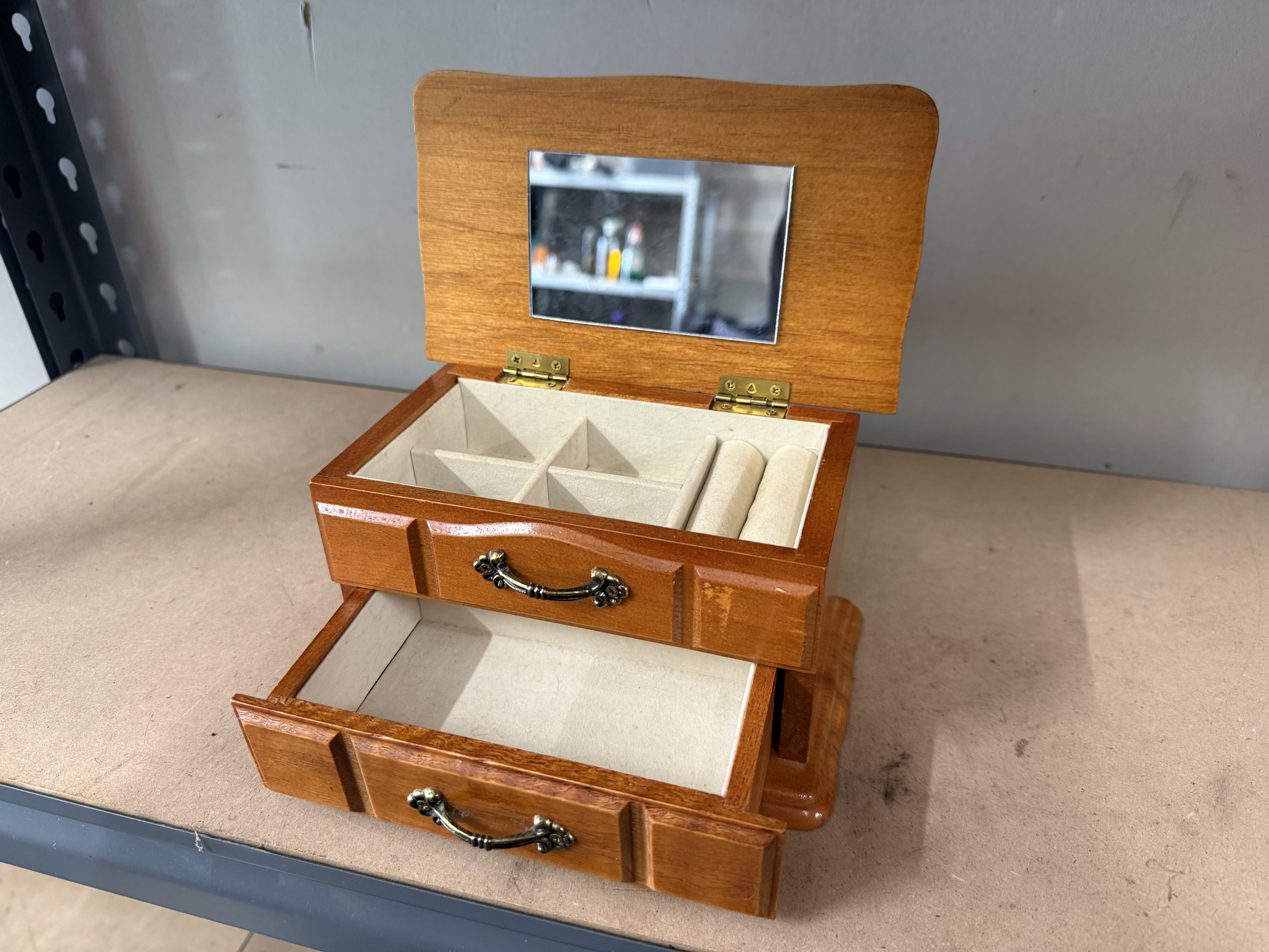 A two-tier wooden jewellery box with mirror and drawer