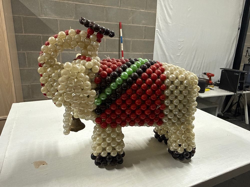 Lot 19: A Colourful Beaded Elephant Ornament Featuring a Brass Bell