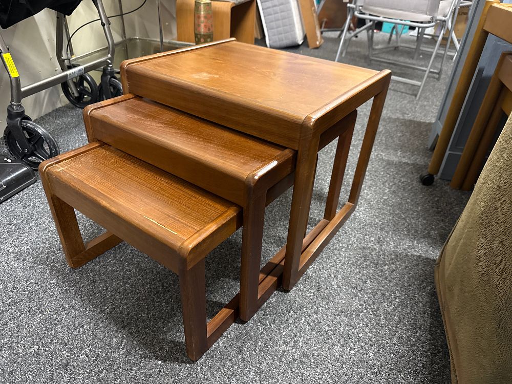 Lot 117: A set of three Mid-Century teak nesting tables with lipped edges