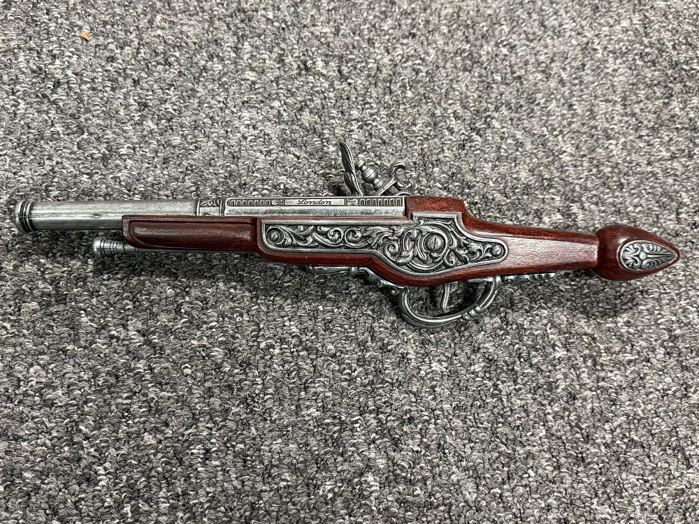 Lot 82: A decorative London engraved replica flintlock pistol with scrollwork