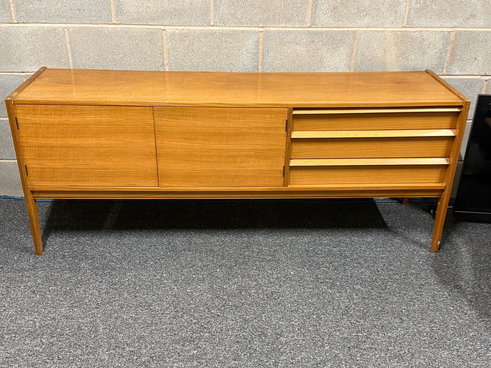 Lot 97: A Younger Mid-century modern teak sideboard with three drawers and cupboards