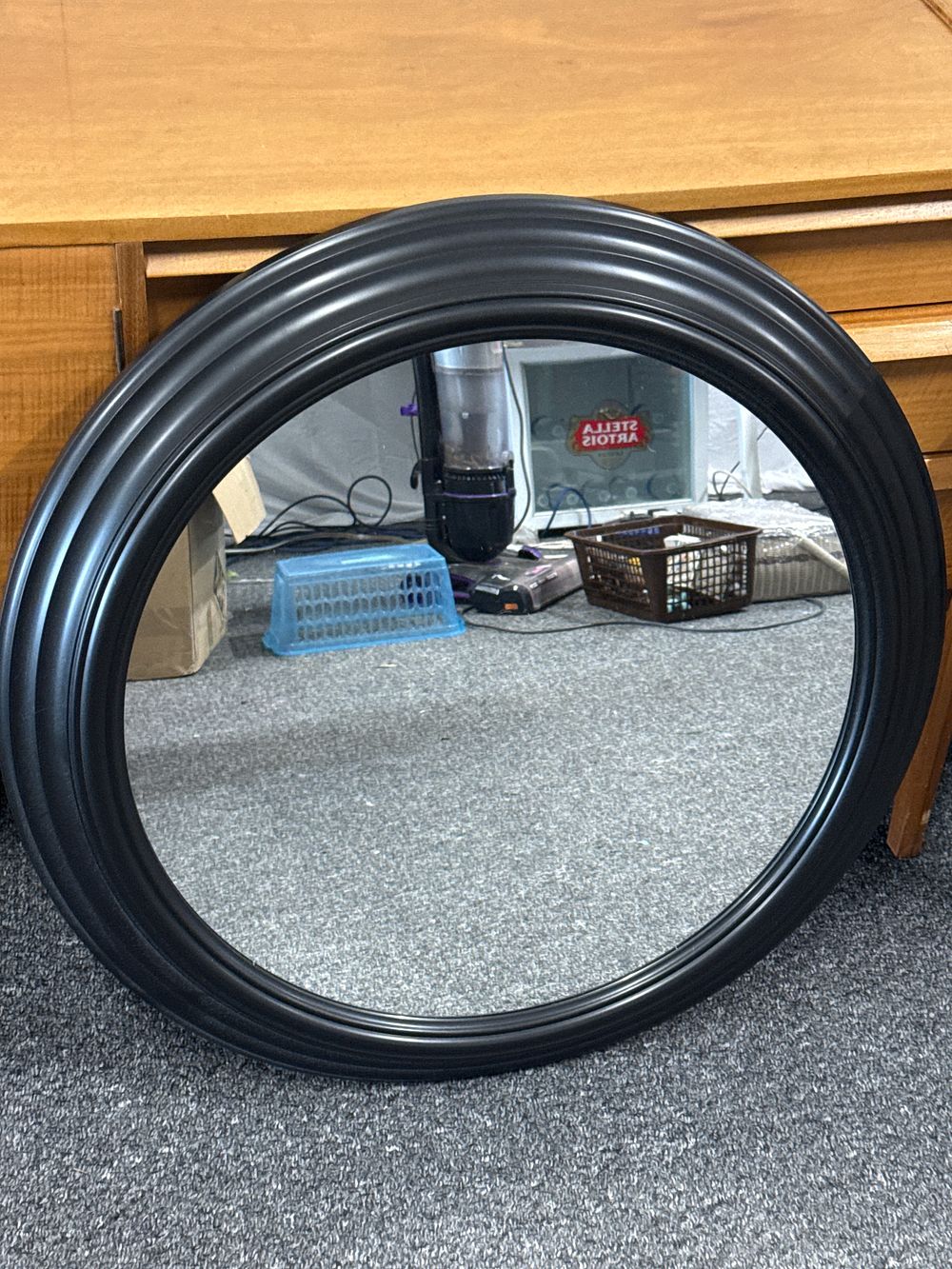 Lot 126: A contemporary circular wall mirror in a black triple-moulded frame