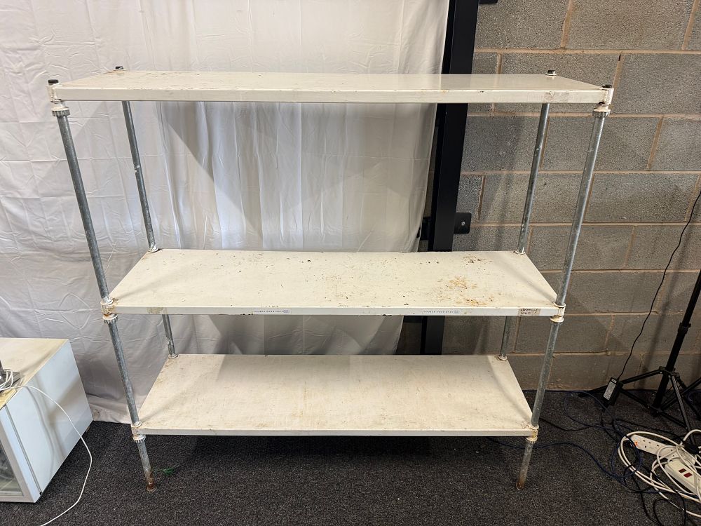 Lot 289: A three-tier industrial metal shelving unit with white shelves 61” tall 60” wide and 18” deep