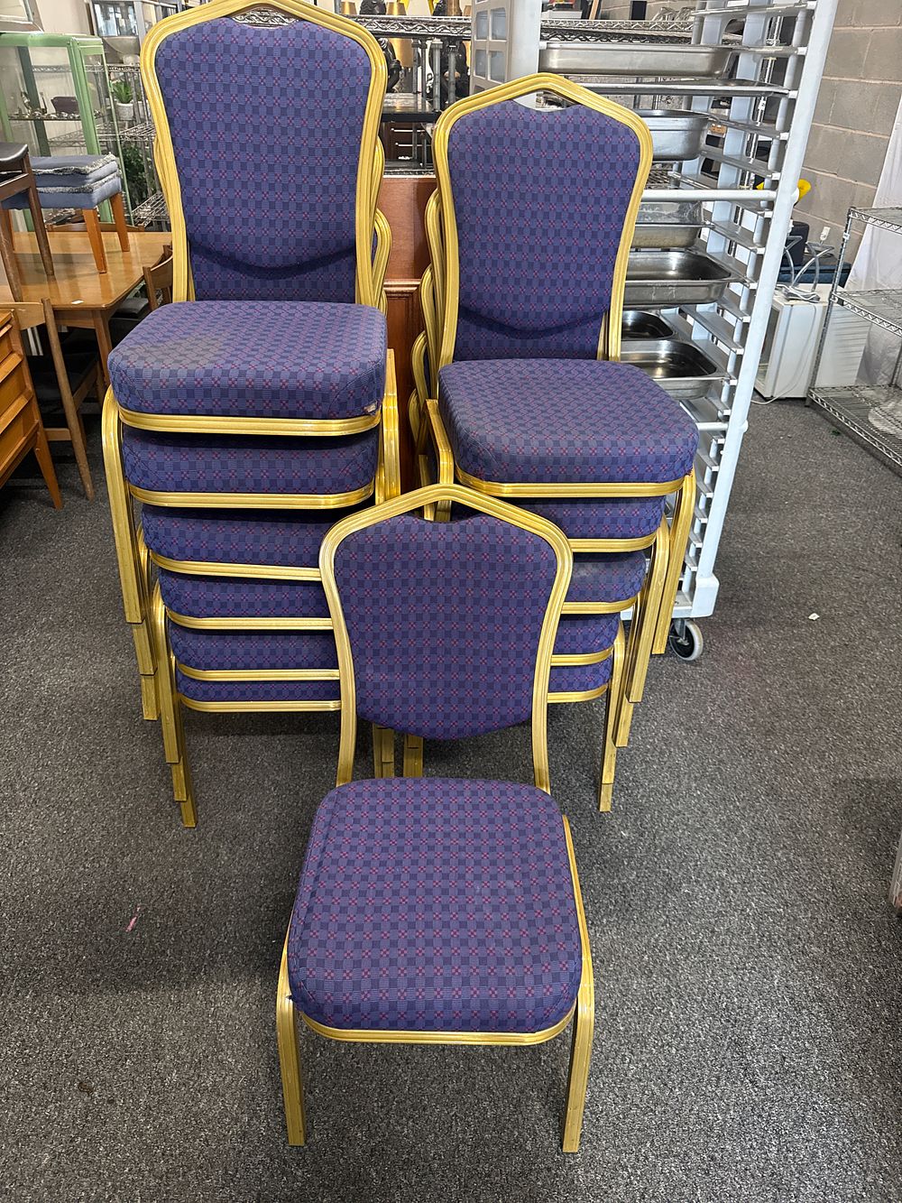 Lot 297: A set of twelve gold-framed stacking banqueting chairs with purple upholstery