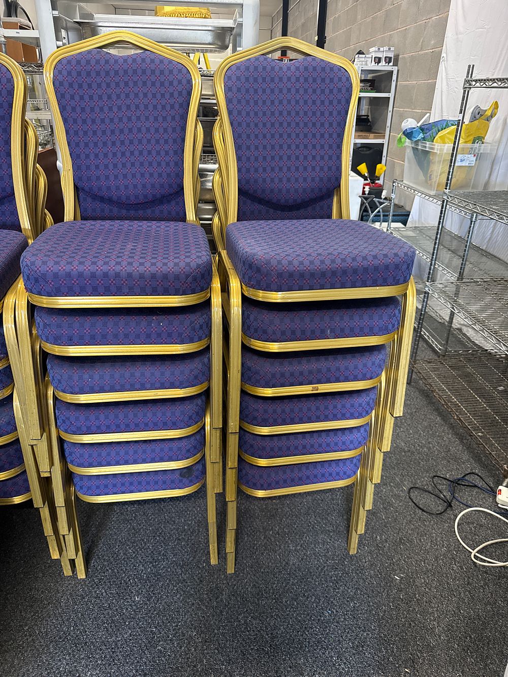 Lot 299: Twelve stackable gold-toned metal and upholstered banquet chairs