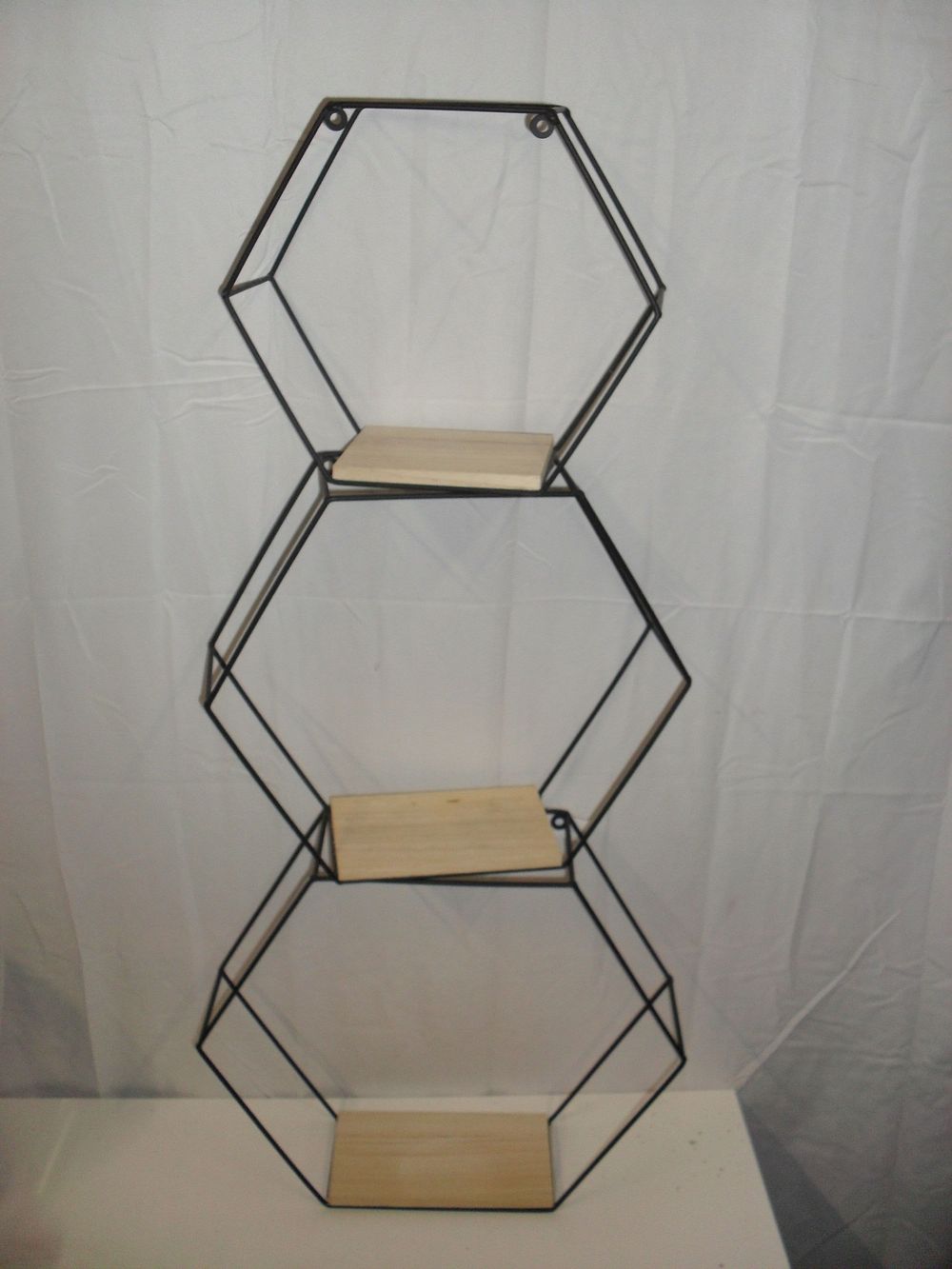 Lot 63: A trio of graduated hexagonal black metal and wood wall shelves
