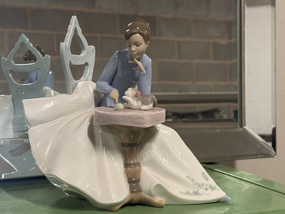 Lot 11: A Nao by Lladró porcelain figurine of a seated woman playing with a kitten