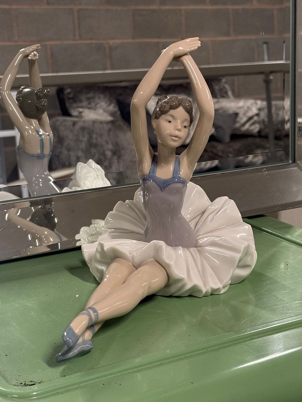 Lot 12: A NAO by Lladro porcelain figurine of a seated ballerina