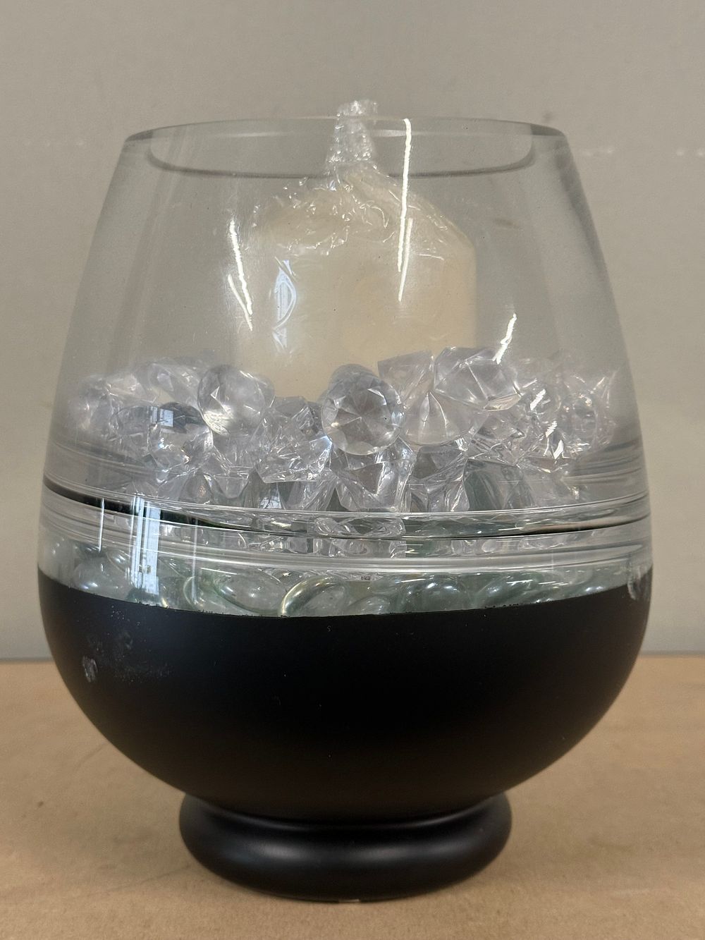 Lot 44: A decorative pillar candle set in a matte black pedestal holder