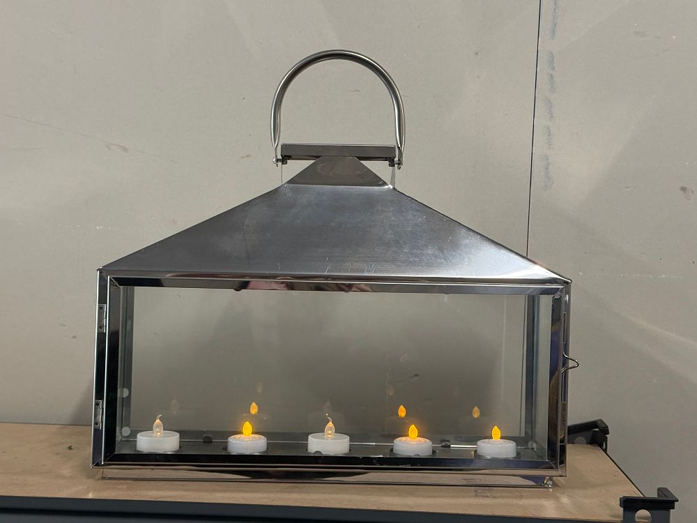 Lot 51: A polished stainless steel and glass hanging lantern with battery opeeated candles