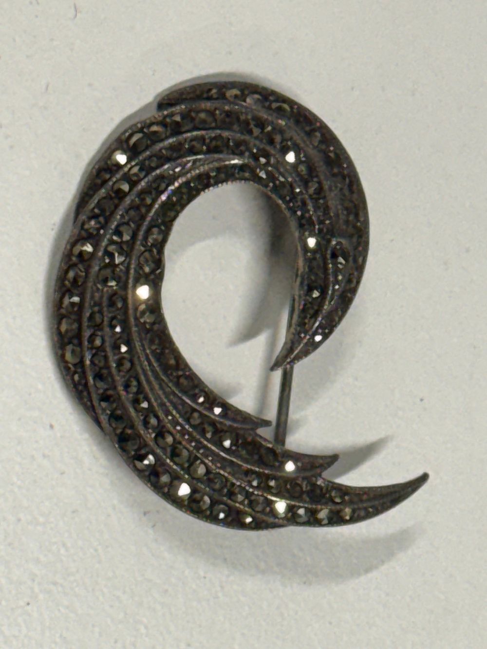 Lot 107: A vintage sterling silver and marcasite scrolling wing brooch