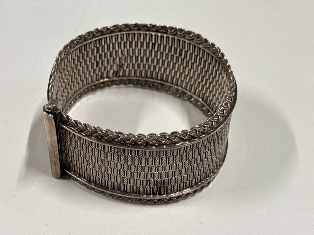 Lot 108: A wide sterling silver woven mesh cuff bracelet 36.8 Grams