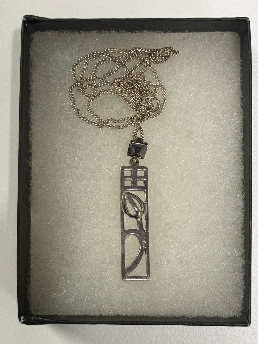 Lot 121: A Modernist style silver openwork rectangular pendant and chain
