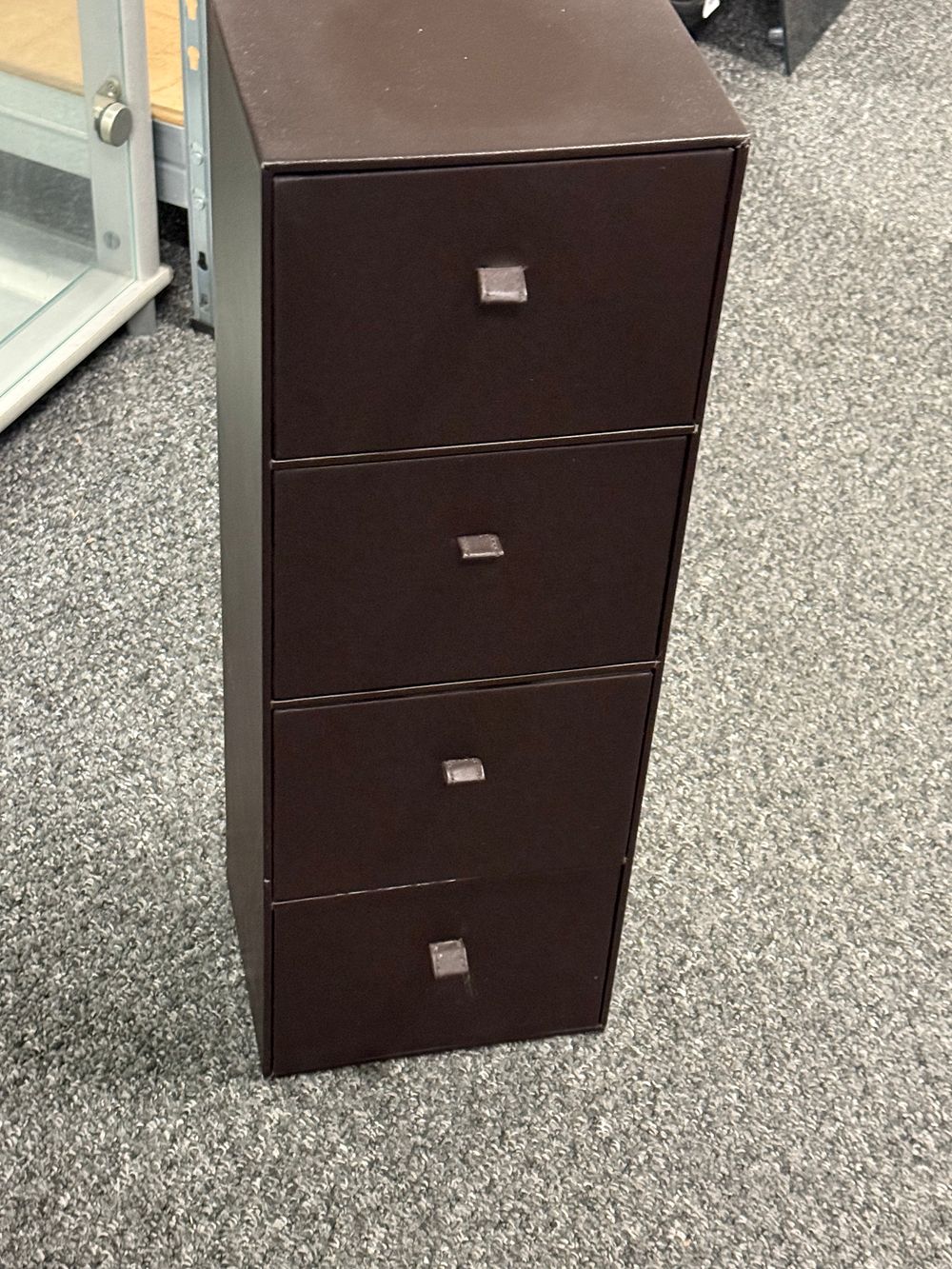 Lot 137: A contemporary dark brown faux leather four drawer storage chest
